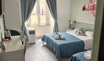 a hotel room with two beds and a window at Girasole Guesthouse in Rome