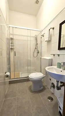 a bathroom with a shower and a toilet and a sink at Girasole Guesthouse in Rome