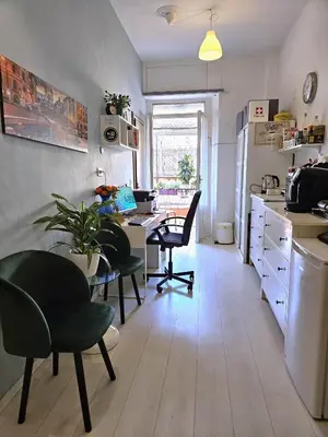 a kitchen with a table and chairs and a desk at Girasole Guesthouse in Rome