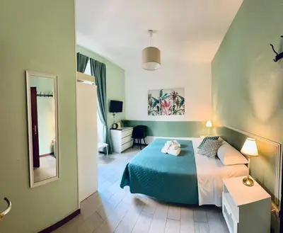 a bedroom with a blue bed and a mirror at Girasole Guesthouse in Rome
