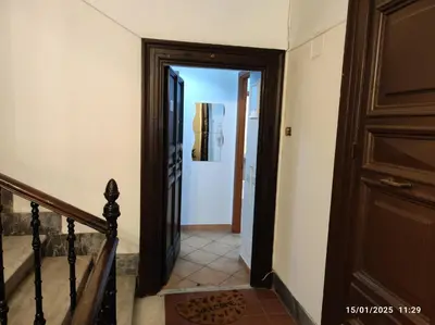 a hallway with a wooden door and a staircase at Il Grillo ai Fori Romani in Rome