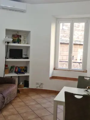 a living room with a couch and a window at Il Grillo ai Fori Romani in Rome