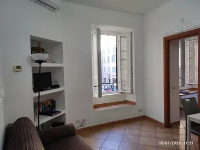 a living room with a couch and two windows at Il Grillo ai Fori Romani in Rome
