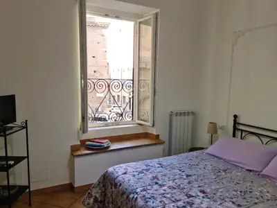 a bedroom with a bed and a window at Il Grillo ai Fori Romani in Rome