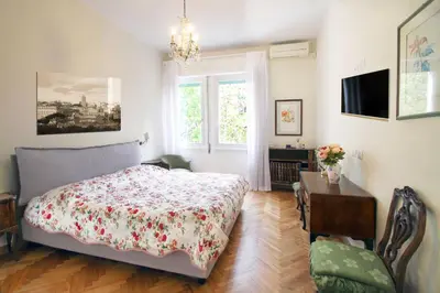 a bedroom with a bed and a desk and a window at Charming apartment in Trastevere in Rome