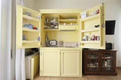 a kitchen with yellow cabinets and a sink at Charming apartment in Trastevere in Rome