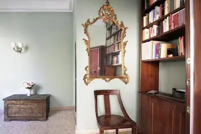 a room with a mirror and a chair and a table at Charming apartment in Trastevere in Rome