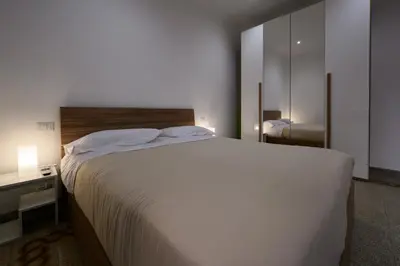 a bedroom with a large white bed and a mirror at Sora Rosa in Rome
