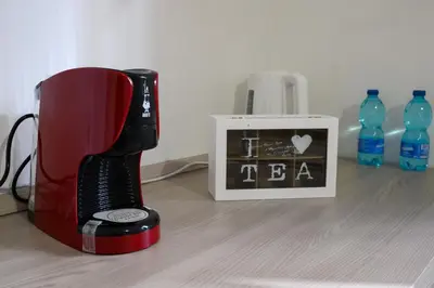 a red blender next to a picture and bottles of water at Sora Rosa in Rome
