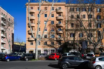 a parking lot with cars parked in front of a building at Sora Rosa in Rome