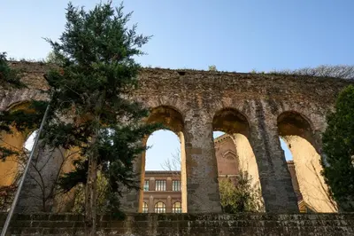 a brick wall with three arches in front of a building at Sora Rosa in Rome