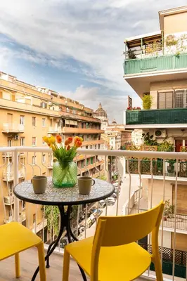a table with two chairs and a vase of flowers on a balcony at Vatican sweet view in Rome