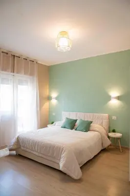 a bedroom with a large bed with a green wall at Vatican sweet view in Rome
