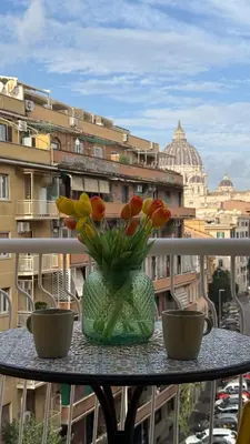 a vase of flowers sitting on a table on a balcony at Vatican sweet view in Rome