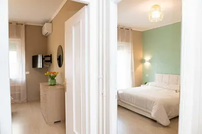 a bedroom with a white bed and a green wall at Vatican sweet view in Rome