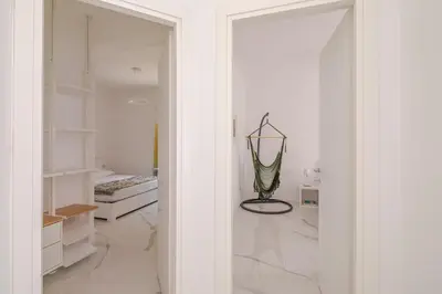 a room with white walls and a glass door leading to a bedroom at Sunrise House - San Paolo in Rome
