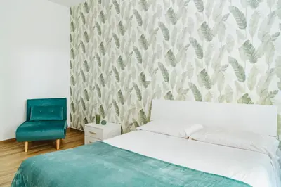 a bedroom with a bed and a blue chair at Suite 155 in Rome