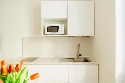 a white kitchen with a microwave and a sink at Suite 155 in Rome
