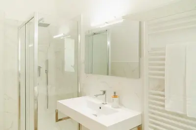 a white bathroom with a sink and a shower at Suite 155 in Rome