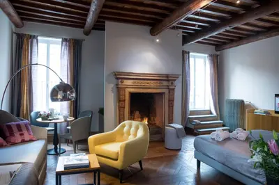 a living room with a fireplace and a yellow chair at Grand Master Suites in Rome