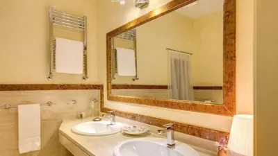 a bathroom with two sinks and a large mirror at Grand Master Suites in Rome