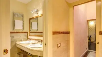 a bathroom with two sinks and a mirror and a shower at Grand Master Suites in Rome