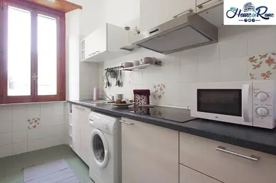 a kitchen with a washing machine and a microwave at Appartamento di Nina in Rome