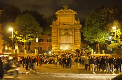 a crowd of people standing around a monument at night at Appartamento di Nina in Rome