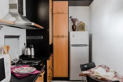 a kitchen with a white refrigerator and a table at Casa Buonarroti, Rome, City Center, Elegant and Quiet Apartment in Rome