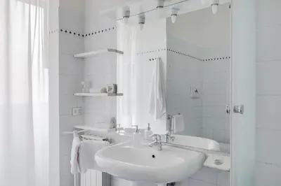 a white bathroom with a sink and a shower at Casa Buonarroti, Rome, City Center, Elegant and Quiet Apartment in Rome