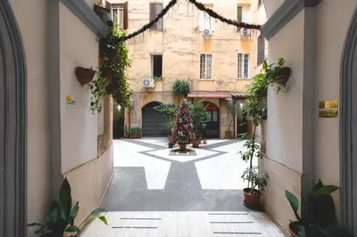 an alley in an old building with potted plants at Casa Buonarroti, Rome, City Center, Elegant and Quiet Apartment in Rome