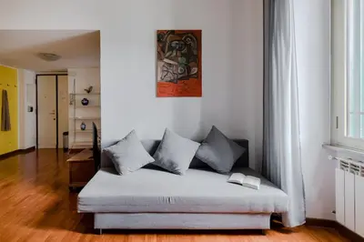 a couch sitting in a living room with a window at Casa Buonarroti, Rome, City Center, Elegant and Quiet Apartment in Rome