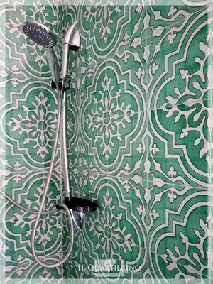 a bathroom with a green and white wall at Il Quartierino in Rome
