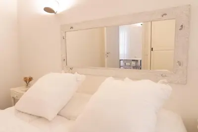 a bedroom with a mirror above a bed with white pillows at Domus Machiavelli in Rome