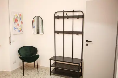 a room with a green chair and a mirror at Casa Marini in Rome