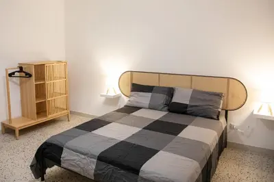 a bedroom with a large bed with two lamps at Casa Marini in Rome