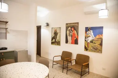a room with a table and chairs and posters on the wall at Casa Marini in Rome