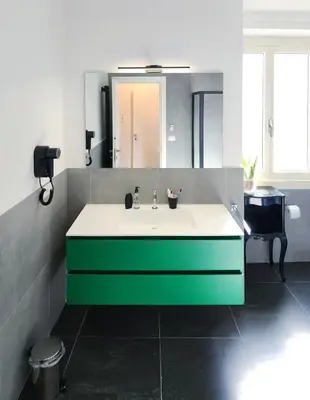 a bathroom with a green and white sink and a mirror at Prisma Rooms in Rome