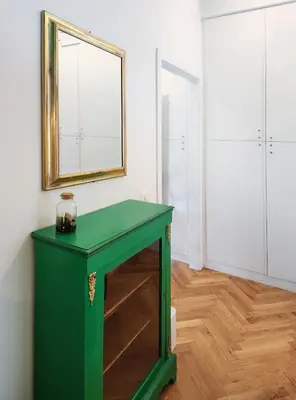 a green table in a room with a mirror at Prisma Rooms in Rome