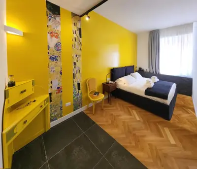 a bedroom with a bed and a yellow wall at Prisma Rooms in Rome