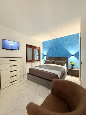 a bedroom with a large bed and a chair at ROME PLACE guest house in Rome