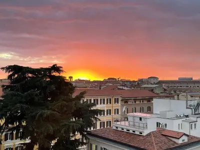 a city skyline with the sun setting in the background at ROME PLACE guest house in Rome