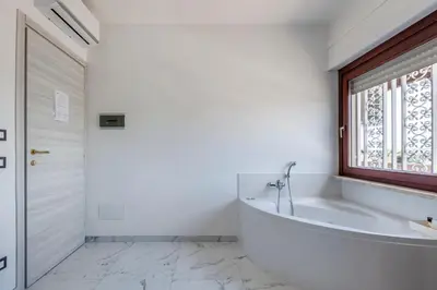 a white bathroom with a tub and a window at ROME PLACE guest house in Rome