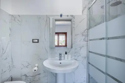 a white bathroom with a sink and a mirror at ROME PLACE guest house in Rome
