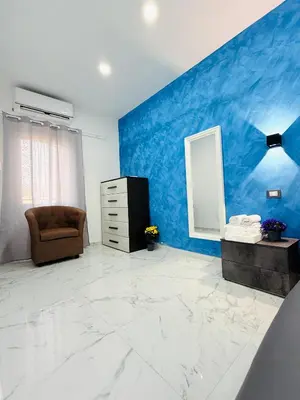a room with a blue wall with a chair and a mirror at ROME PLACE guest house in Rome
