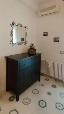 a black dresser in a room with a mirror at Nico's Apartment in Rome