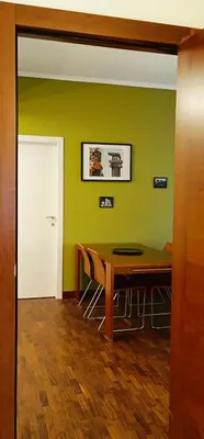 a dining room with a table and a green wall at Nico's Apartment in Rome