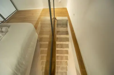 a staircase leading up to a bed in a room at Lovely Nest With Balcony by The Spanish Steps in Rome