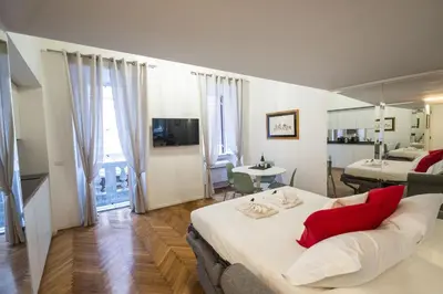 a living room with a large bed and a room with at Lovely Nest With Balcony by The Spanish Steps in Rome