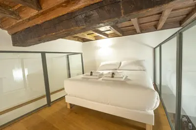 a white bed in a room with glass walls at Lovely Nest With Balcony by The Spanish Steps in Rome
